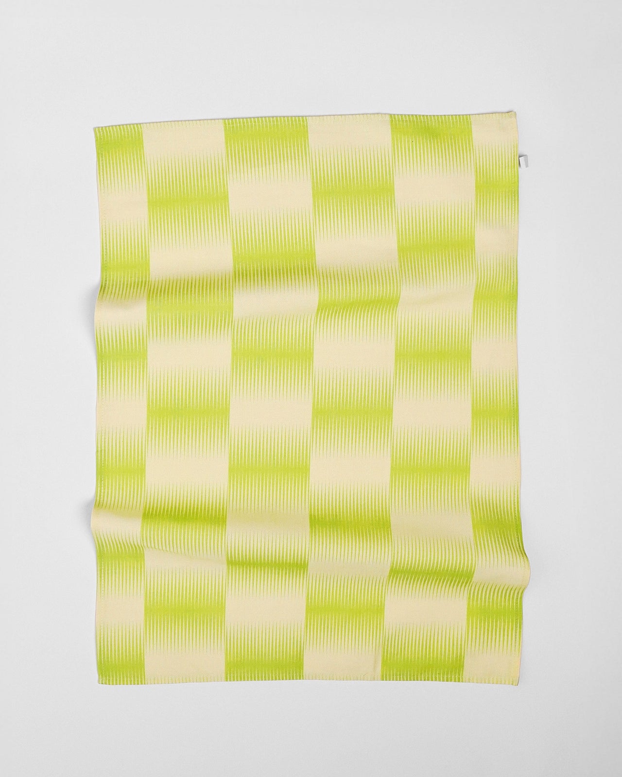 Green and beige checkered fabric on a white background