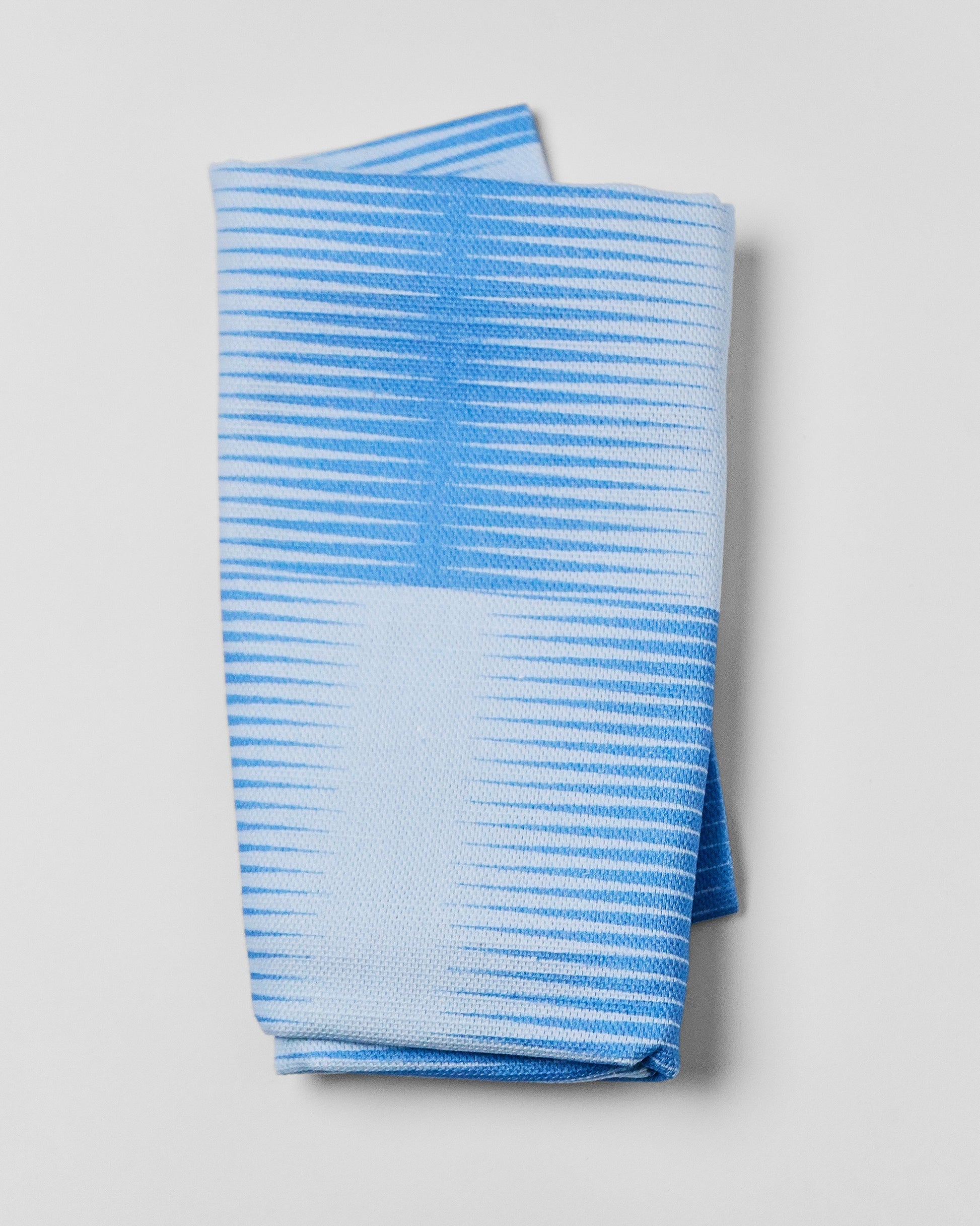 Folded blue and white checkered fabric on a light gray background