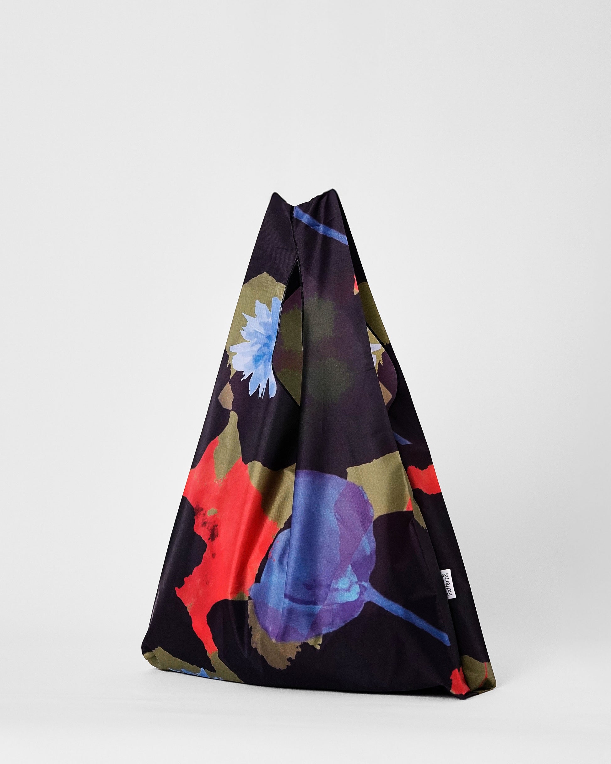 Colorful fabric tote bag with abstract floral patterns on a white background