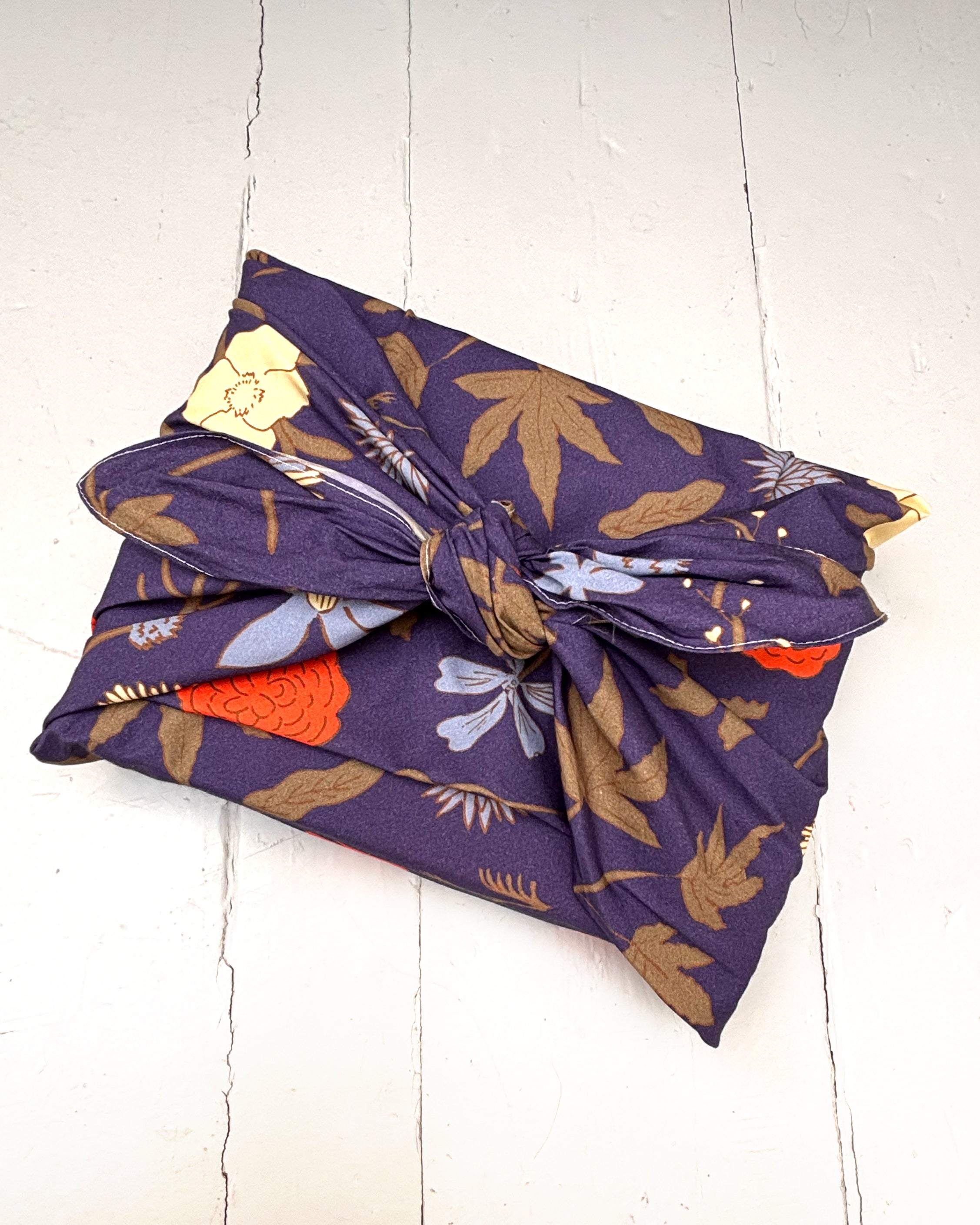 Floral-patterned fabric bundle on a white wooden surface