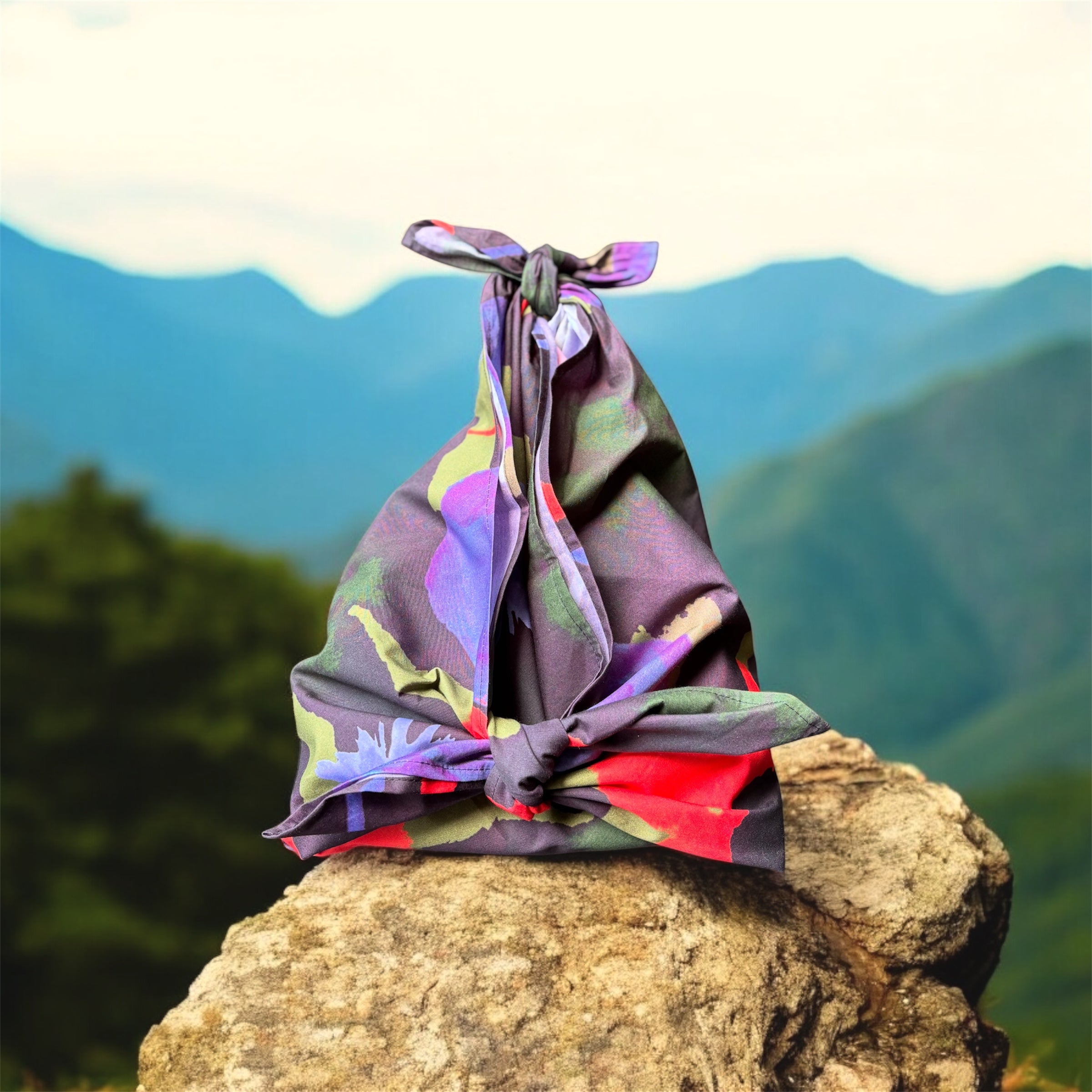 Colorful fabric bundle tied on a rock with a mountainous background