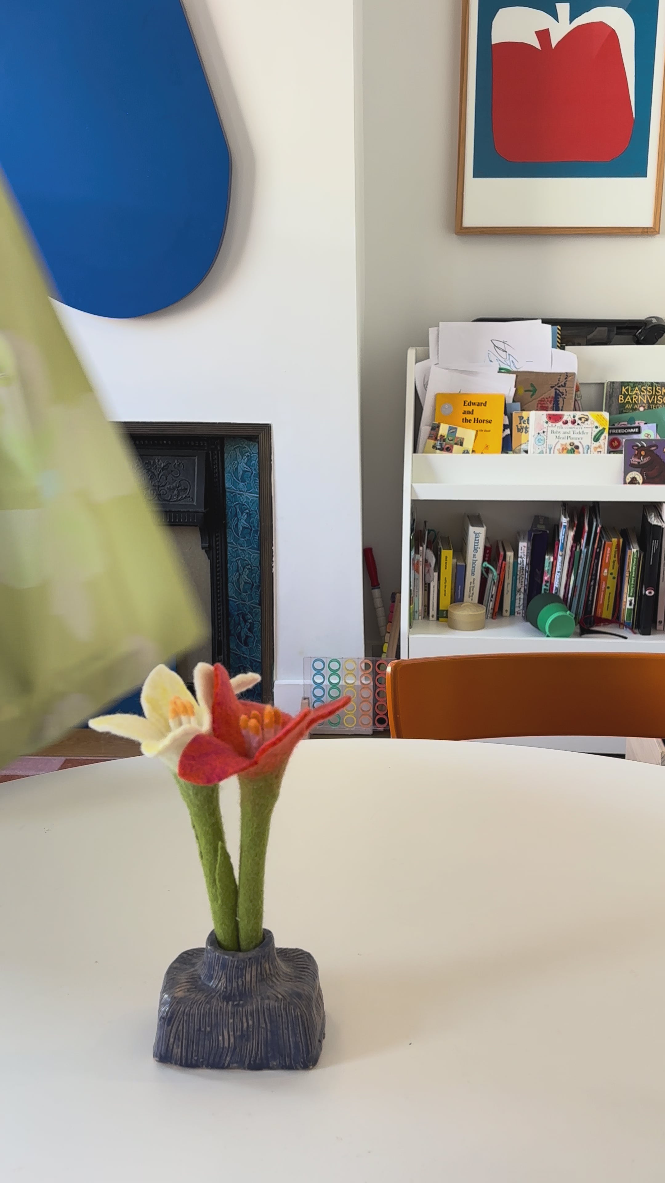 a video of a person resting the lemon yellow tote bag on a white table, taking the contents out of the bag and placing them on the table